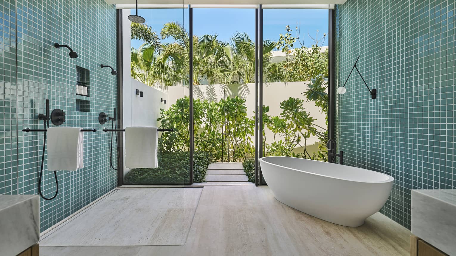 Large bathroom with turquoise wall tiles, walk-in shower, standalone tub, and walk-out shower in a private villa at Four Seasons Resort and Residences Los Cabos