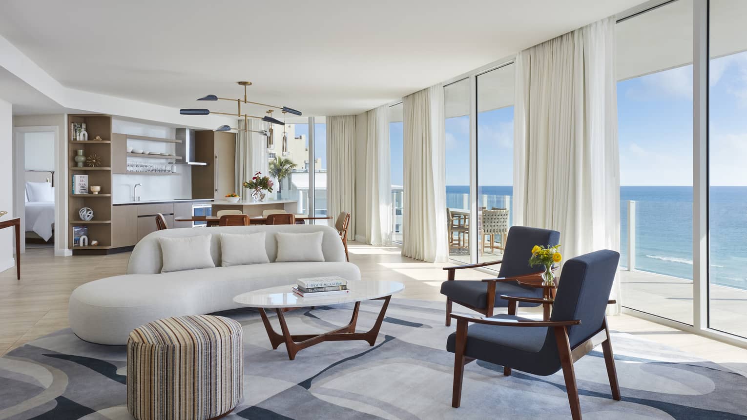 Living room and dining room with wall of windows, ocean view