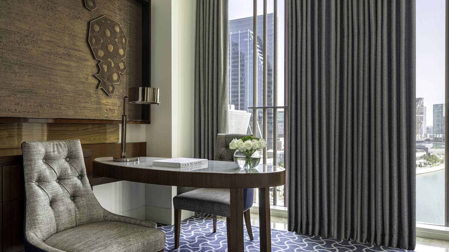 Hotel room with desk and wall of windows