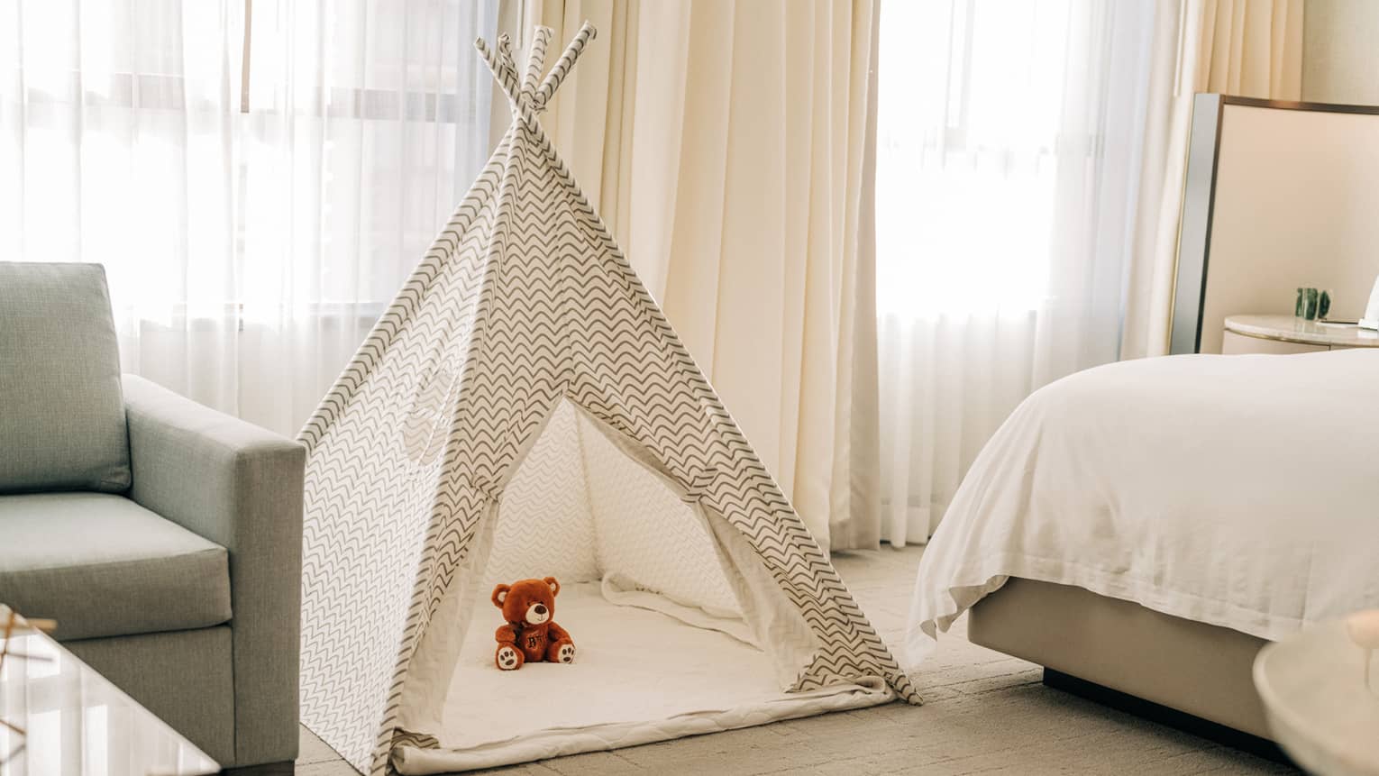 A kids tent with a stuffed animal in a guest room