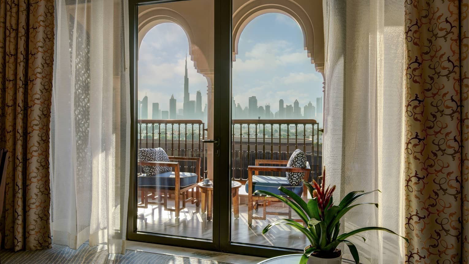 Glass doors lead out to private balcony with two chairs