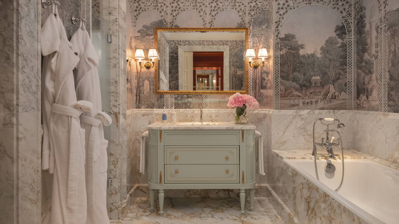 Elegant hotel bathroom with fresco-looking wallpaper, marble tile and wall sconces