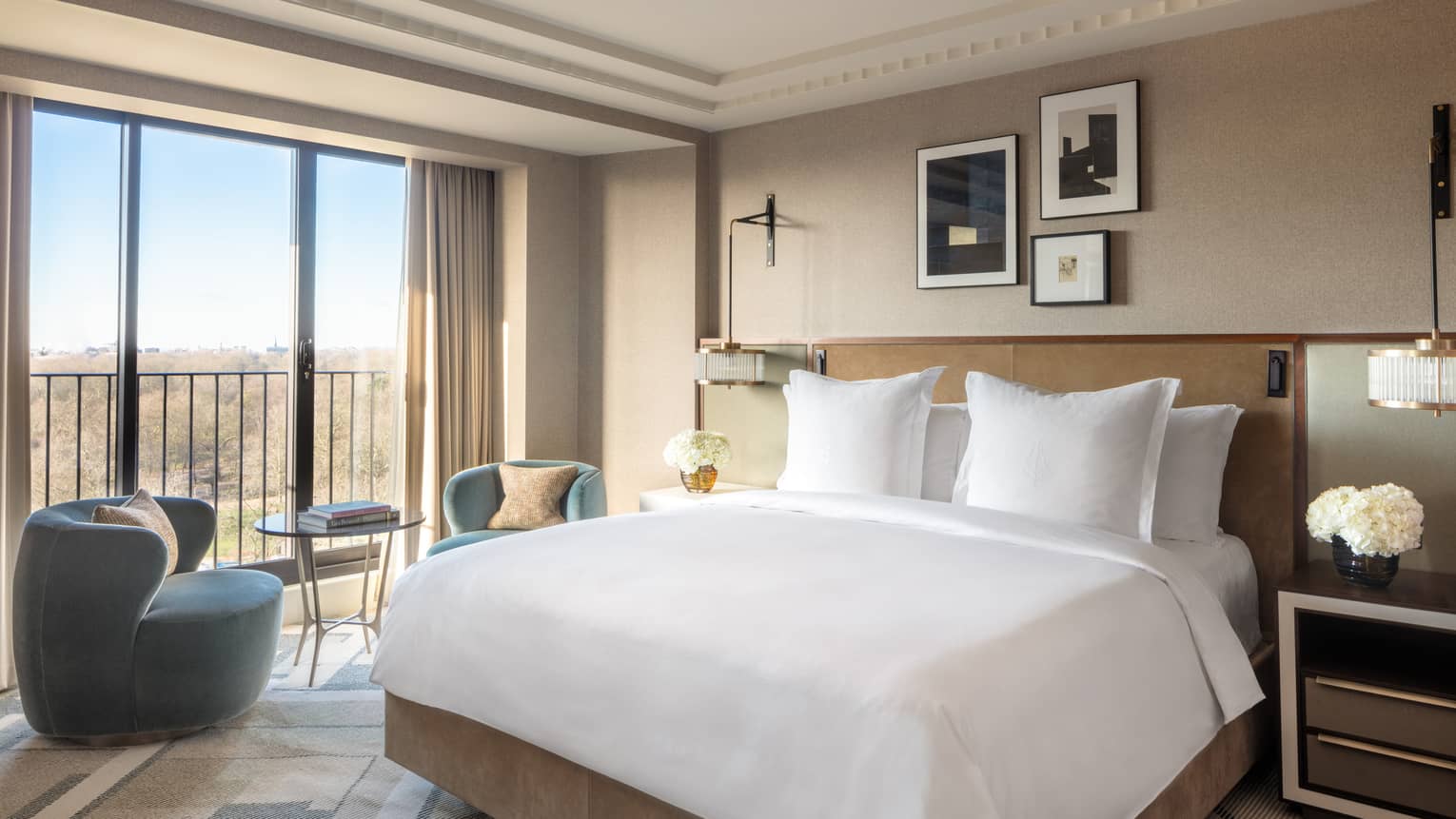 Elegant and cozy premier park view room at the Four Seasons London Park Lane in Mayfair. The room features a large king-sized bed with pristine white bedding and multiple pillows. Modern furnishings include a dark blue armchair, a small round table with two chairs, and stylish lamps. Large windows offer a splendid view of the park outside, filling the room with natural light. The decor is complemented by neutral tones, subtle art pieces on the walls, and a sophisticated ambiance,Elegant and cosy Premier Park-View Room at Four Seasons London Park Lane in Mayfair. The room features a large king-sized bed with pristine white bedding and multiple pillows. Modern furnishings include a dark blue armchair, a small round table with two chairs, and stylish lamps. Large windows offer a splendid view of the park outside, filling the room with natural light. The decor is complemented by neutral tones, subtle art pieces on the walls, and a sophisticated ambiance,Elegant and cosy Premier Park-View Room at Four Seasons London Park Lane in Mayfair. The room features a large king-sized bed with pristine white bedding and multiple pillows. Modern furnishings include a dark blue armchair, a small round table with two chairs, and stylish lamps. Large windows offer a splendid view of the park outside, filling the room with natural light. The decor is complemented by neutral tones, subtle art pieces on the walls, and a sophisticated ambiance