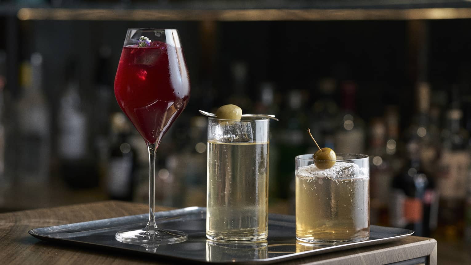 Three different cocktails on a bar tray