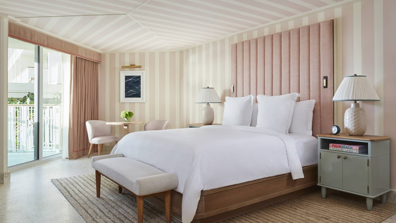 Room with walls and ceiling that have pink stripes, and a glass door.