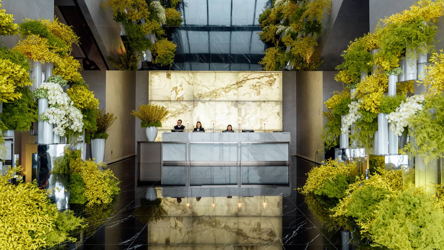 A hotel lobby with yellow flowers lining the hallway