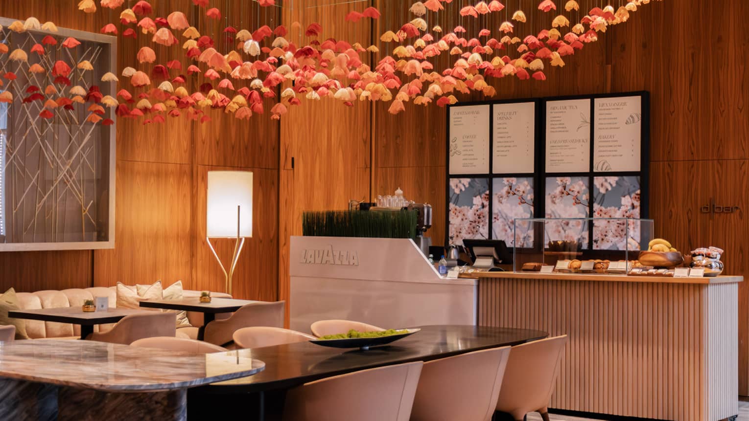 Coffee bar featuring a counter and various tables set beneath a ceiling of hanging pink and red roses