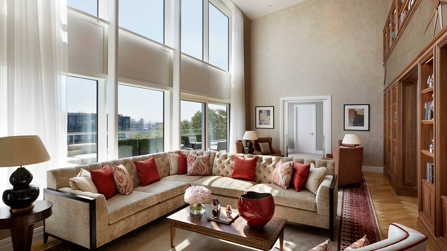 Large L-shaped velvet sofa, living room under sunny, two-storey floor-to-ceiling window