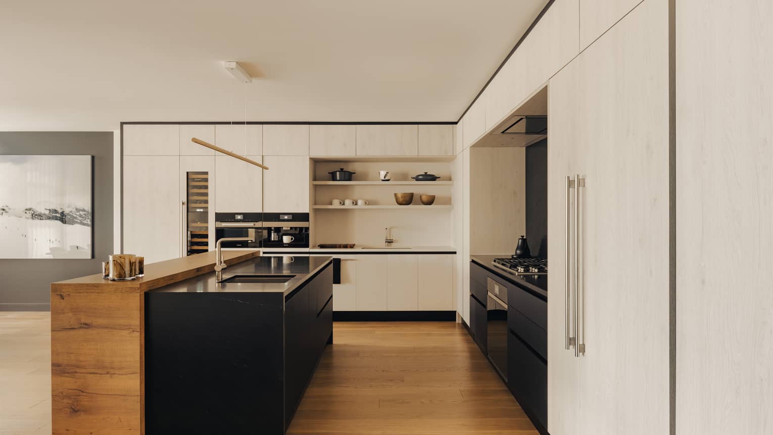 Modern kitchen with black island and connecting wooden bar counter