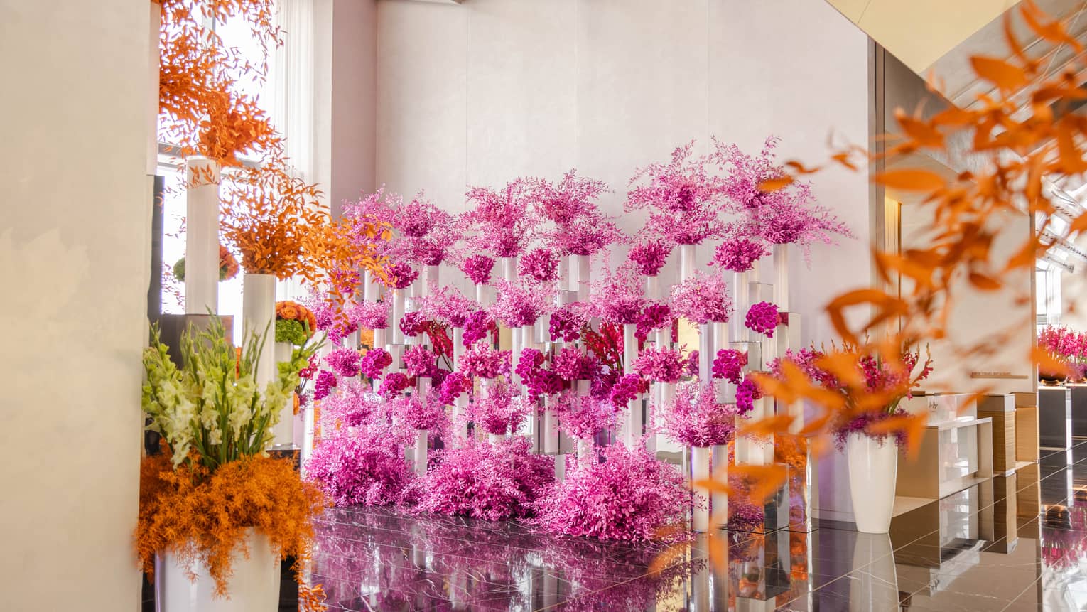 A room with many bouquets of pink and orange flowers
