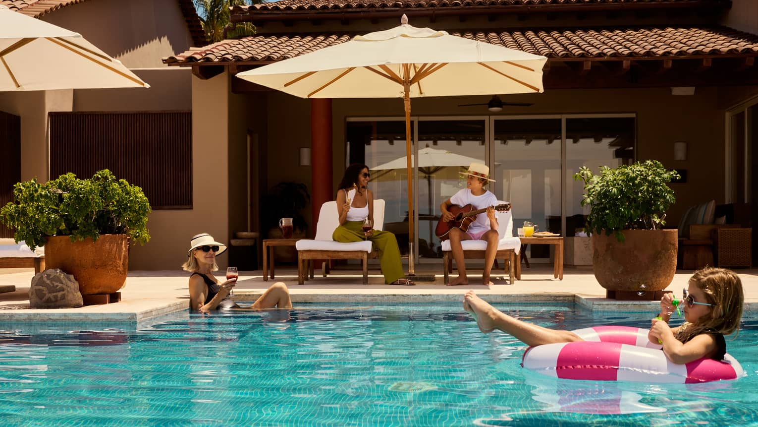 Kids in the pool and parents on deck chairs