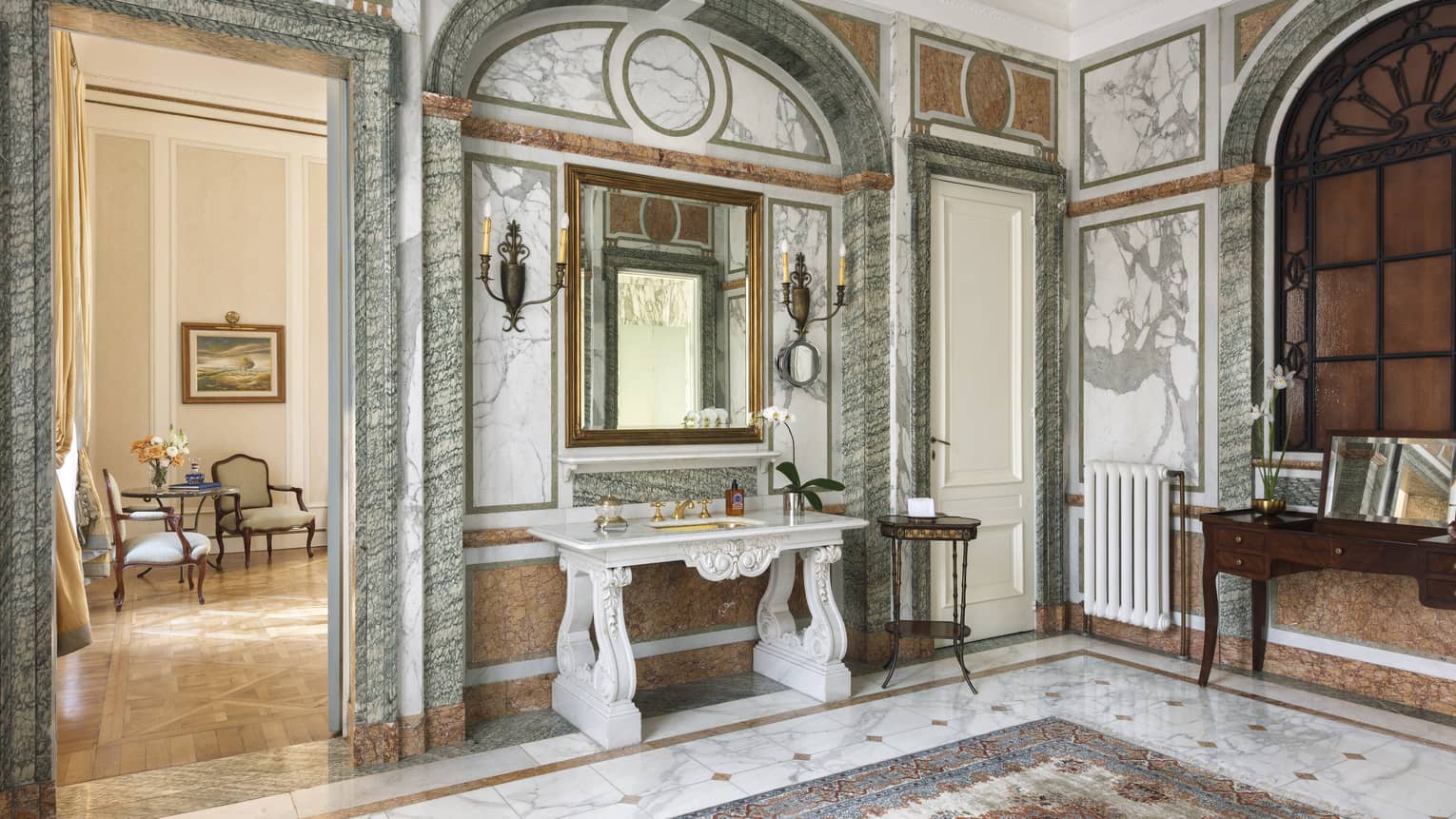 Suite entry way with green and white marble walls and tiled flooring