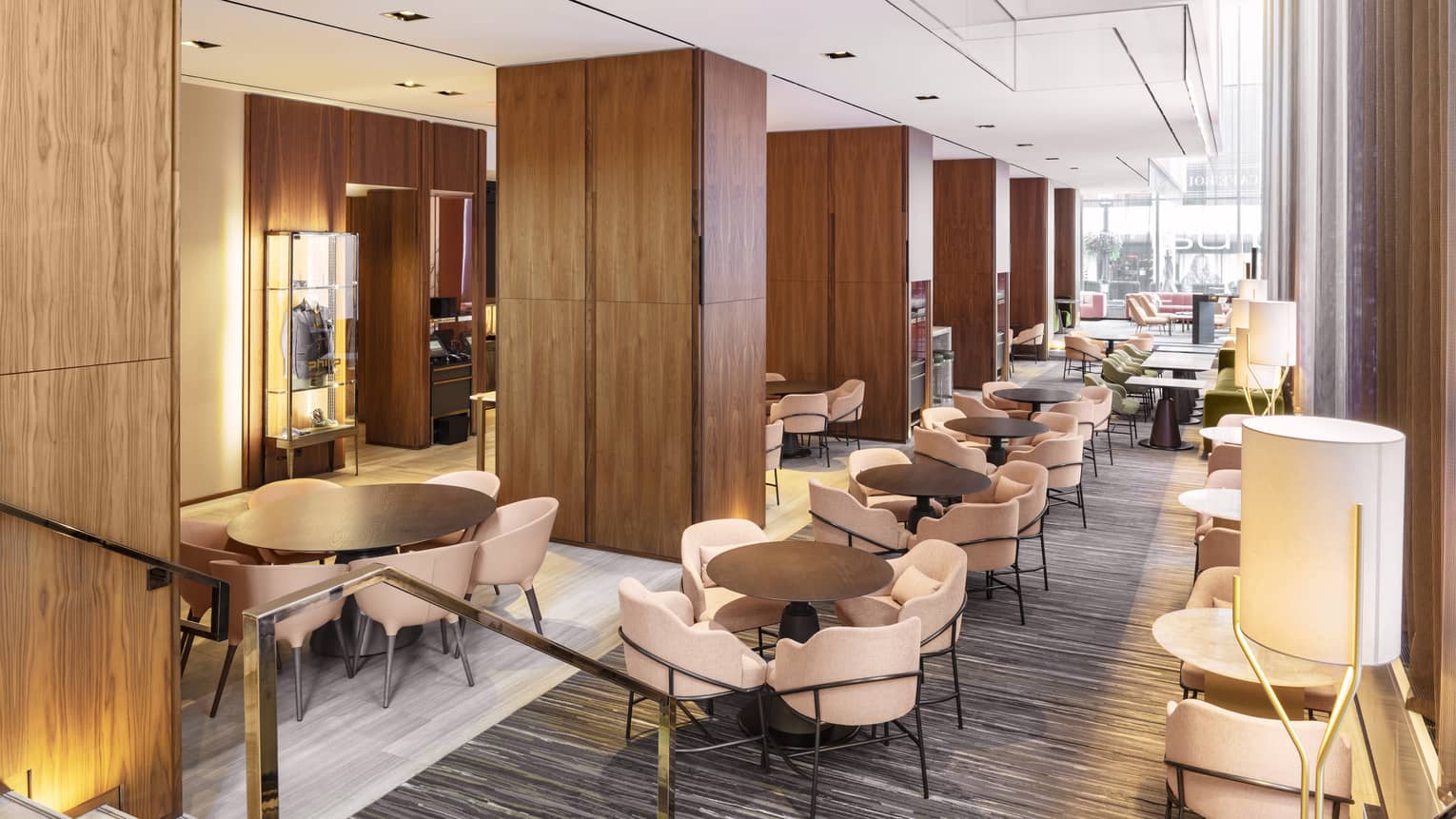 A lounge with upholstered sofas, wood tables and wooden cabinets