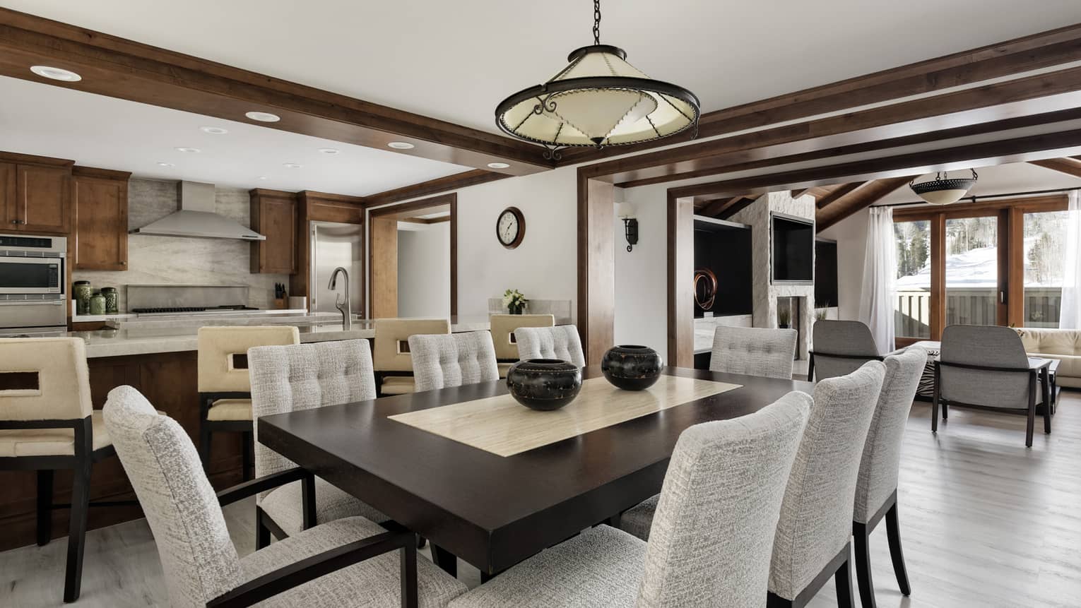 Private residence's dining room with dark wood rectangular table and eight light grey chairs