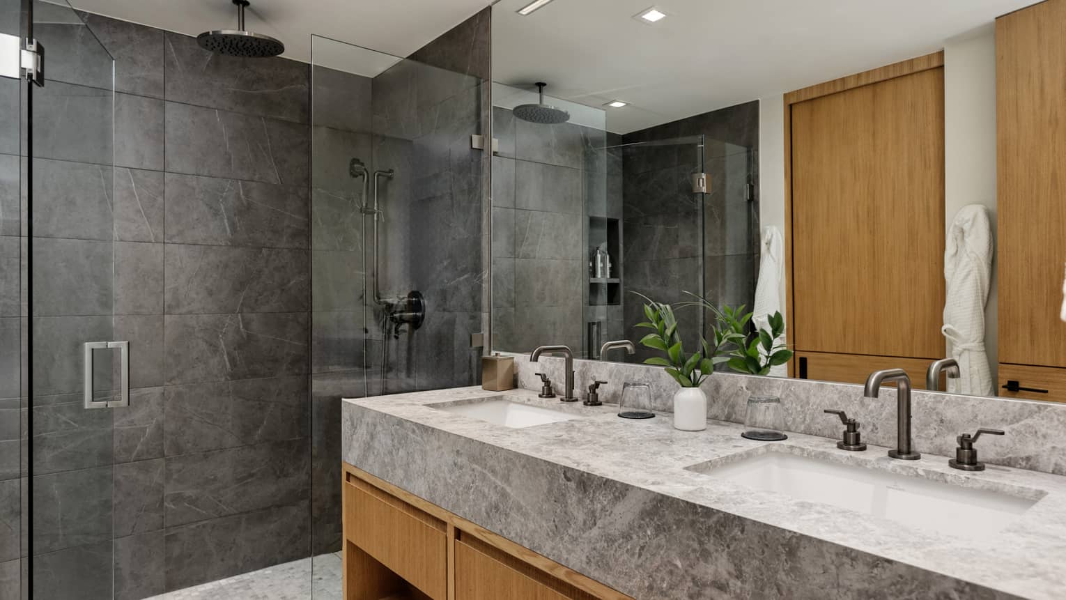Sleek marble and stone bathroom with double vanity and walk-in shower