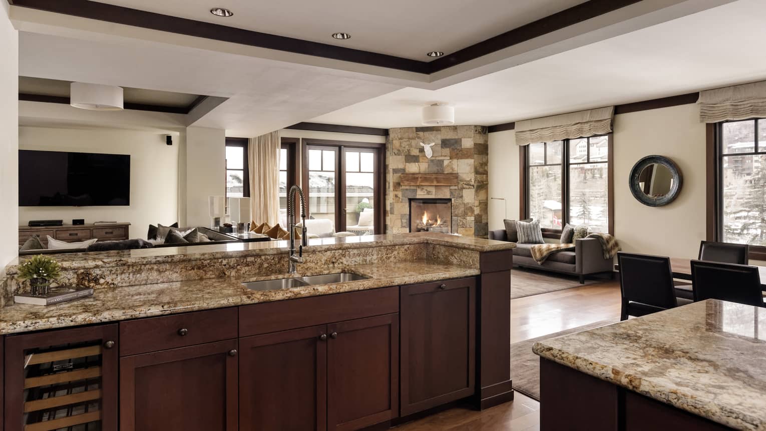 Kitchen of luxury residence with granite countertops and dark wood cupboards