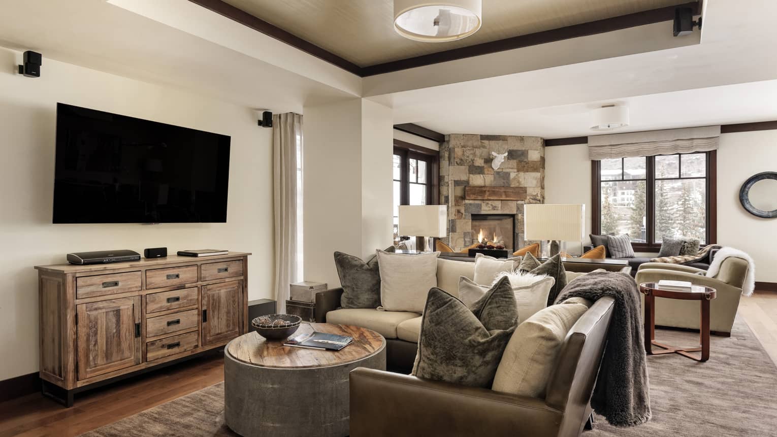 Living room with mountain chic decor, and two sitting areas ? one with a stone fireplace and one with a TV