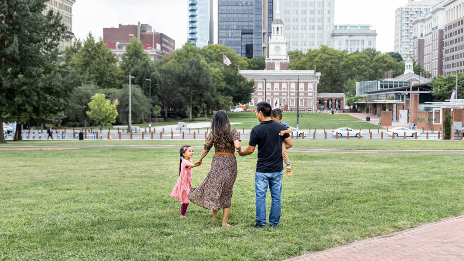 A family of four standing in a park in a city.