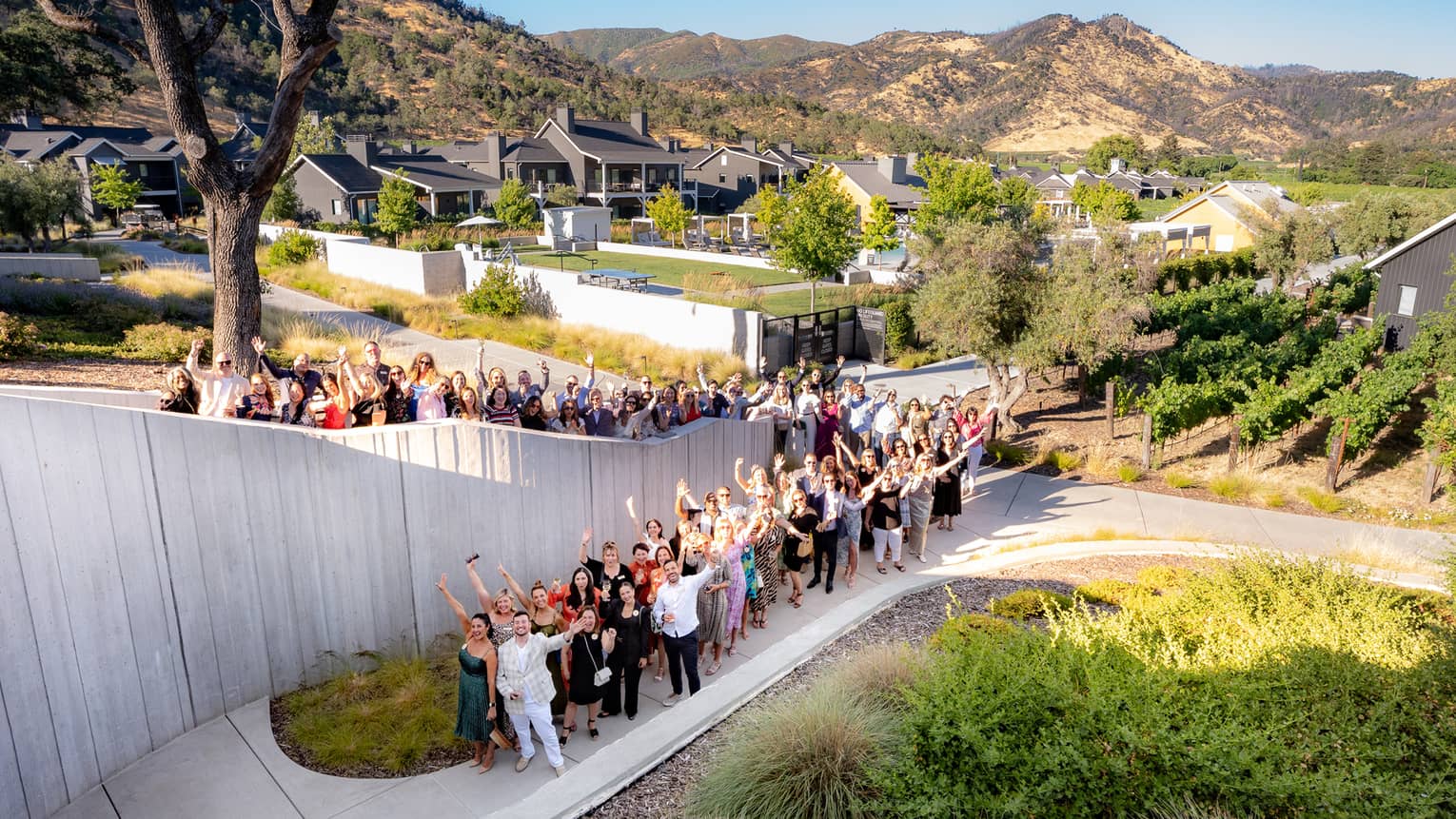Guests standing beside each other in a group and holding their arms in the air