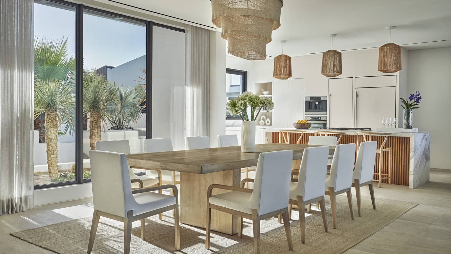 Contemporary wooden dining table for 10 and kitchen with walk-out terrace, private villa at at Four Seasons Resort and Residences Los Cabos