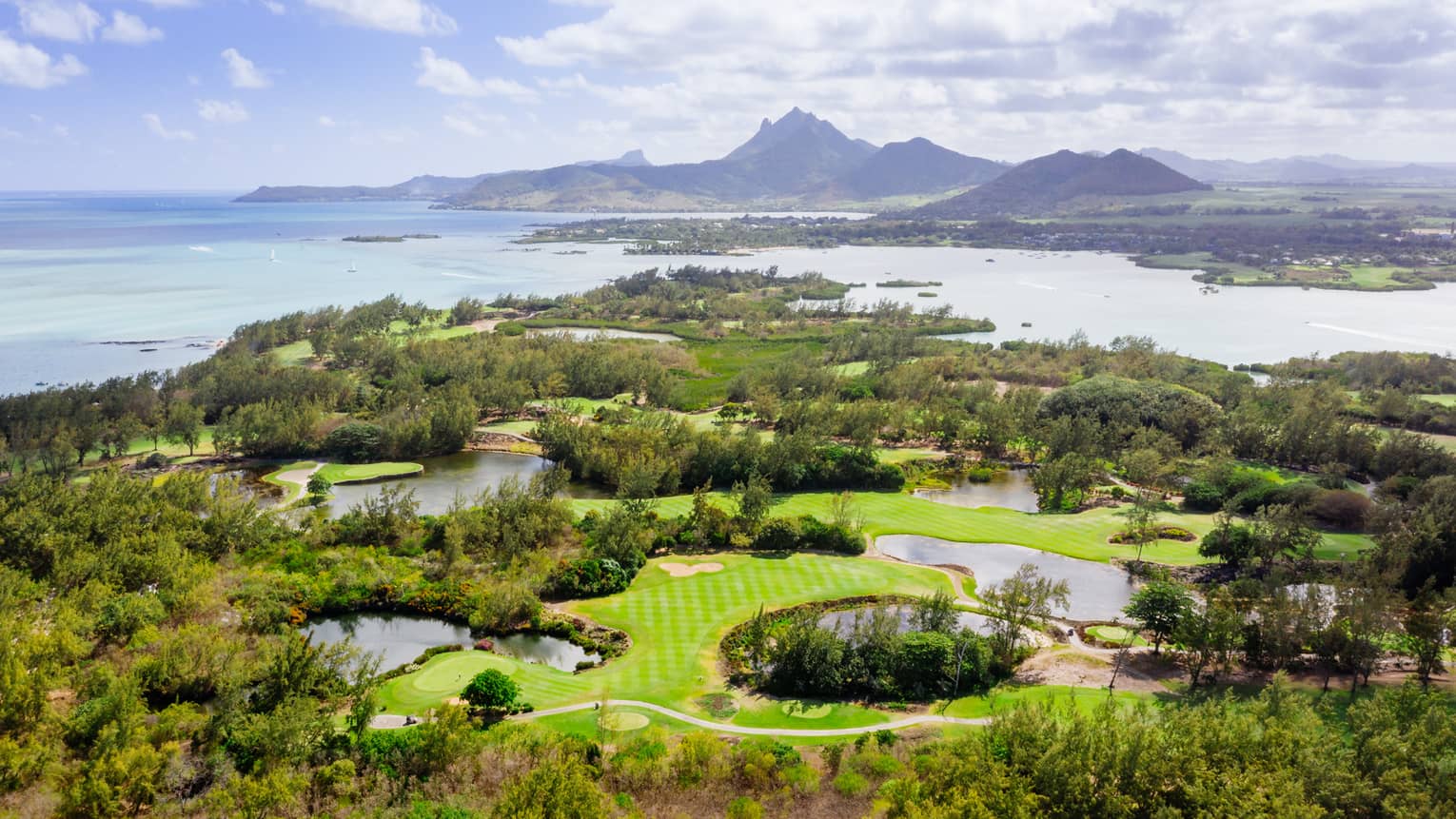 Aerial view of golf course with Indian Ocean and mountains in backdrop