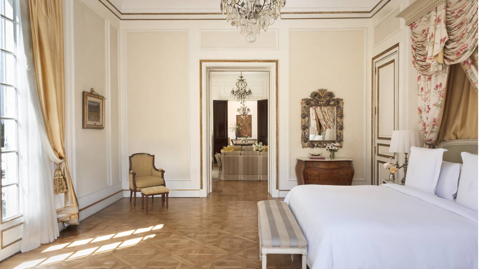 Suite bedroom with parquet floors with a doorway that leads to a living room