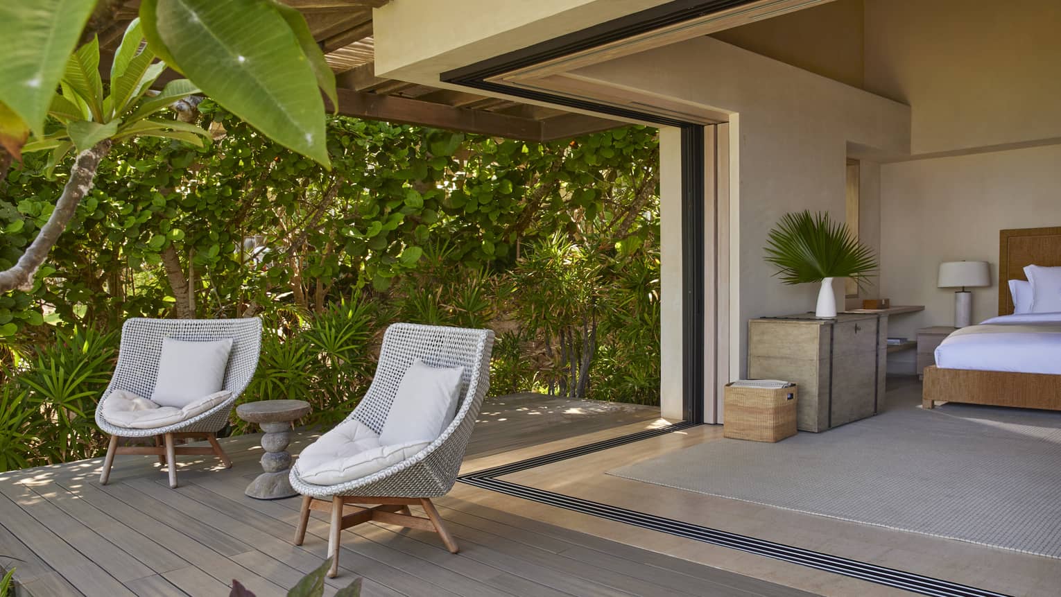 Bedroom opening to private deck with greenery