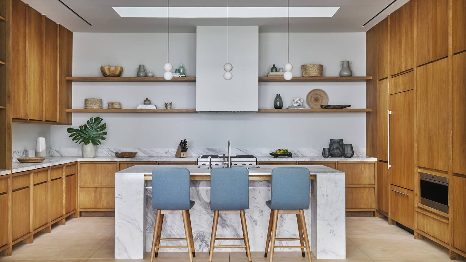Modern kitchen with marble island and three turquoise bar chairs ? luxury villa at Four Seasons Resort and Residences Los Cabos
