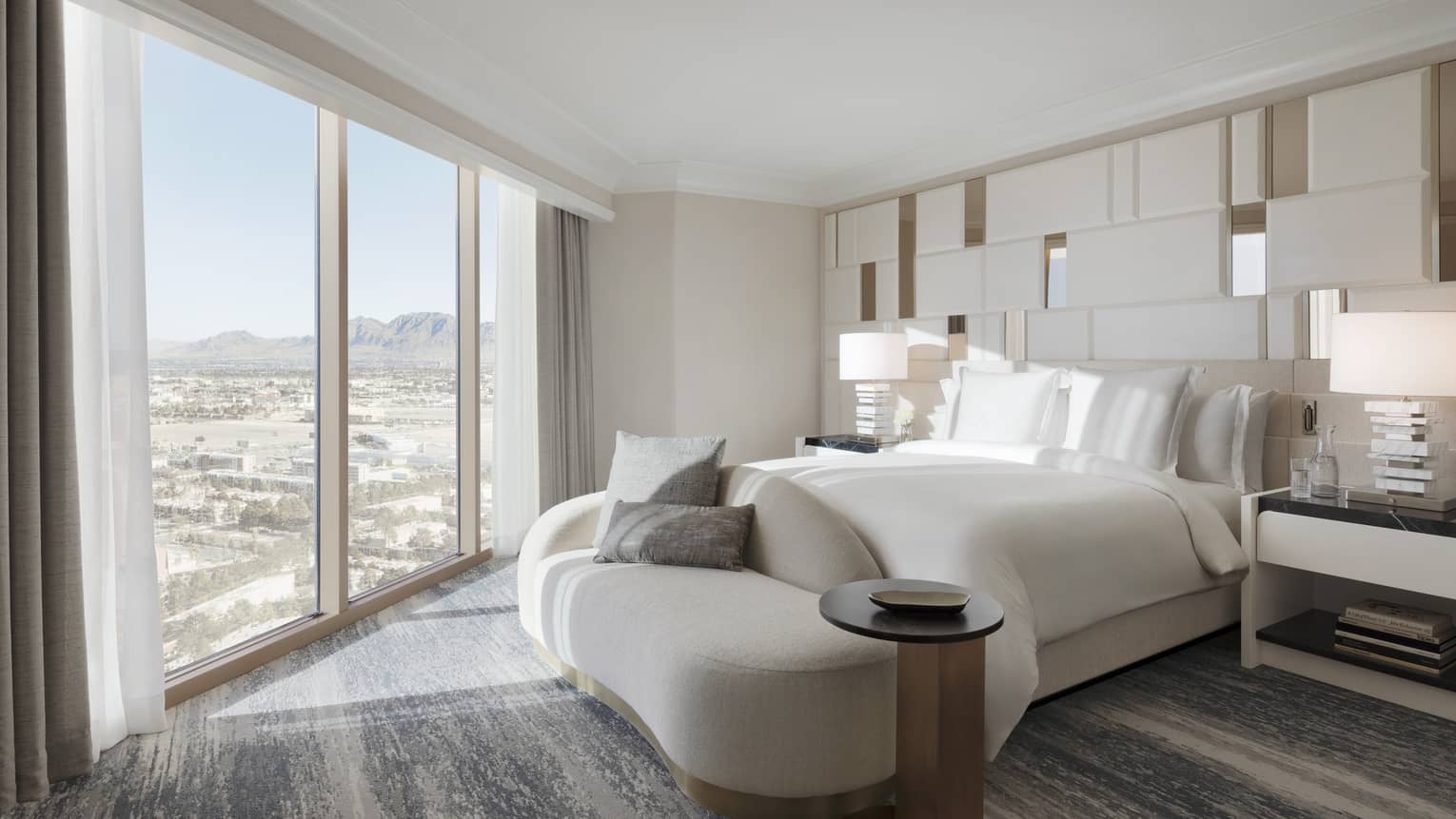 Bedroom with king bed, modern chaise, and wall of windows looking out to Las Vegas at Four Seasons Hotel Las Vegas