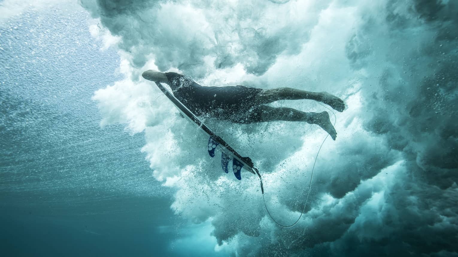 Angled shot of Tropicsurf pro breaking the surface of a wave