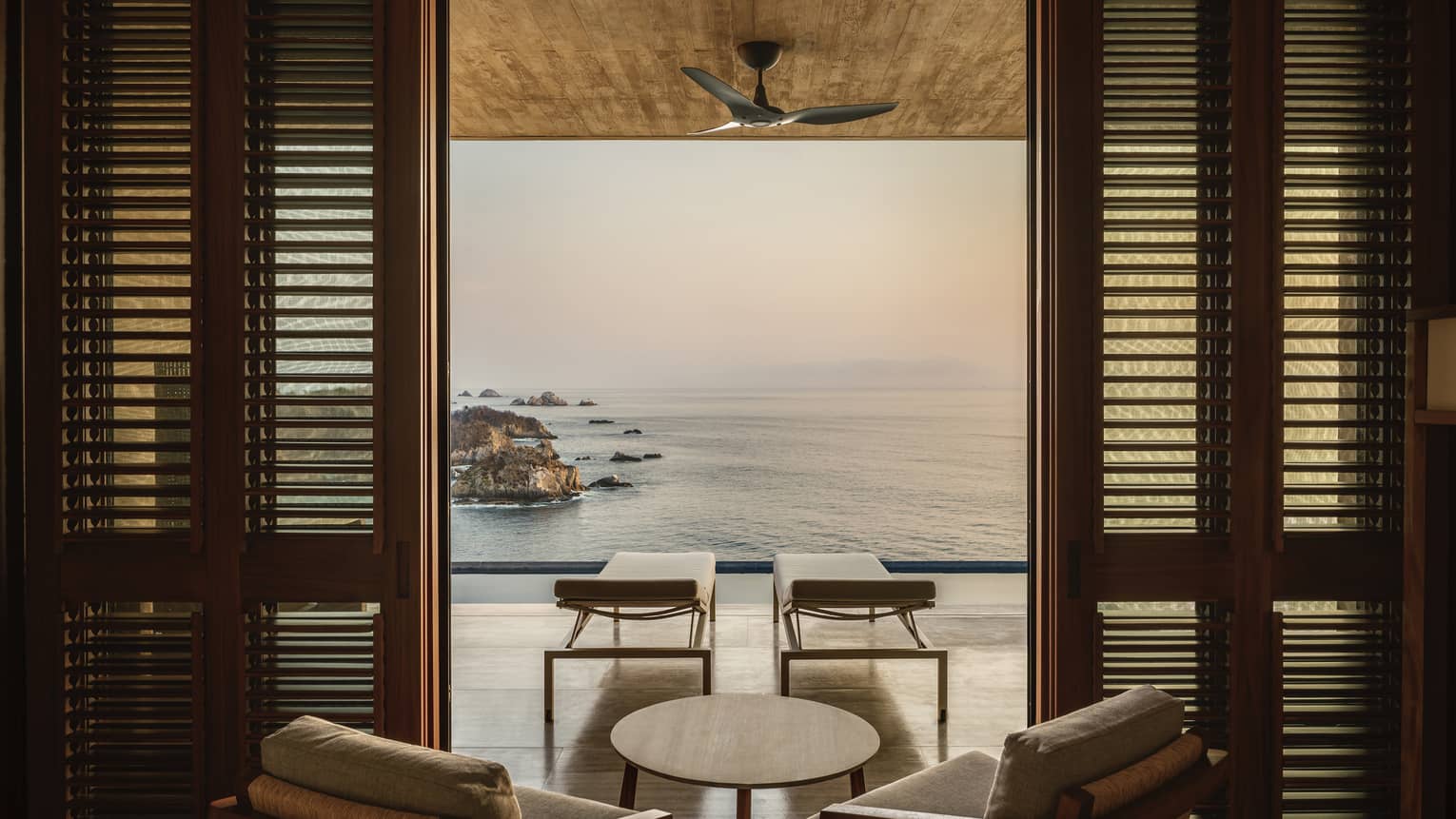 Room with an outdoor balcony overlooking the ocean.