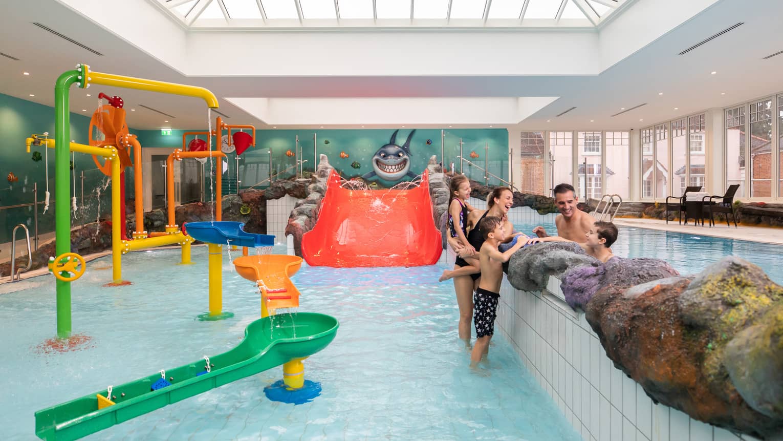 Family talking while standing in Sharkie's colourful indoor pool