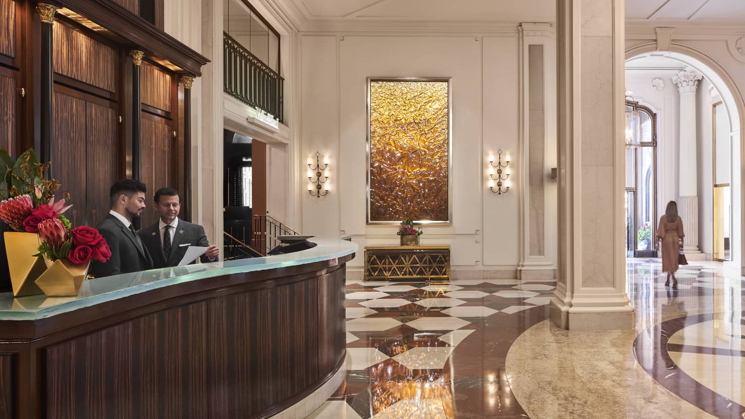 The large concierge desk of a well lit hotel lobby.