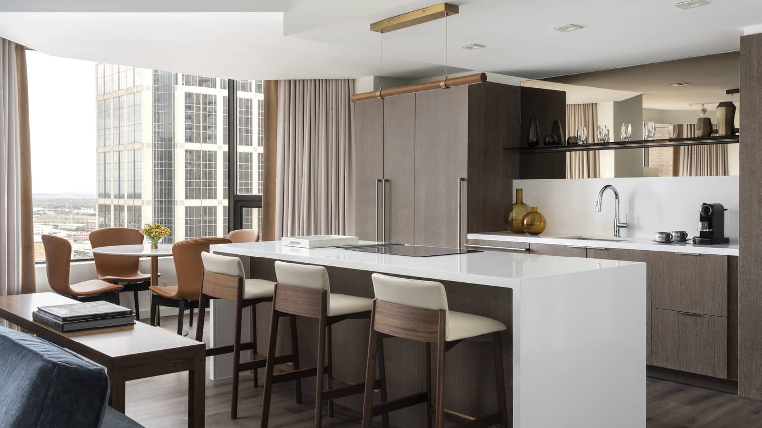 A kitchen area with large island near large windows in a hotel suite.