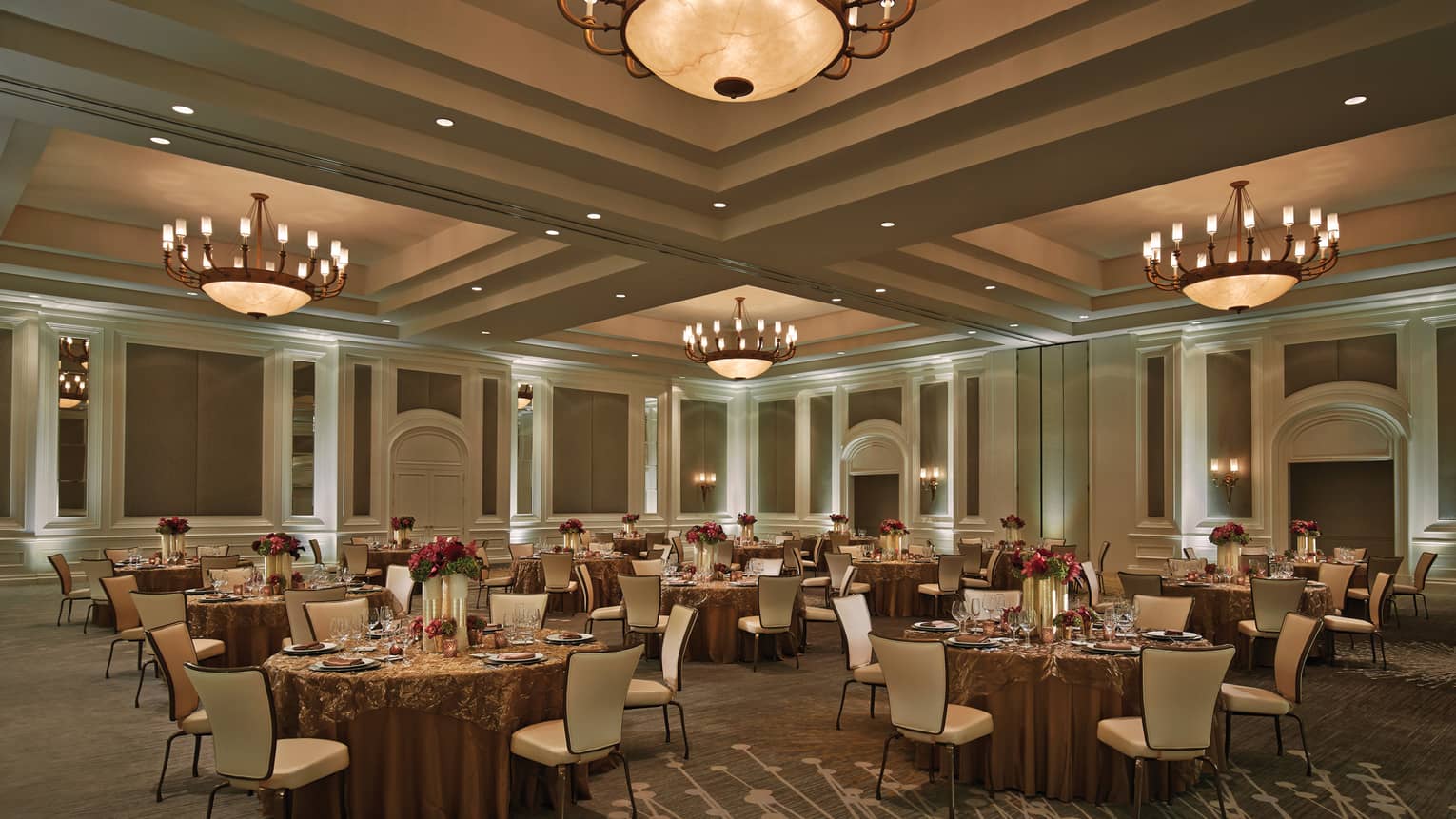 Small round dining tables under large dome lights in Acacia Ballroom
