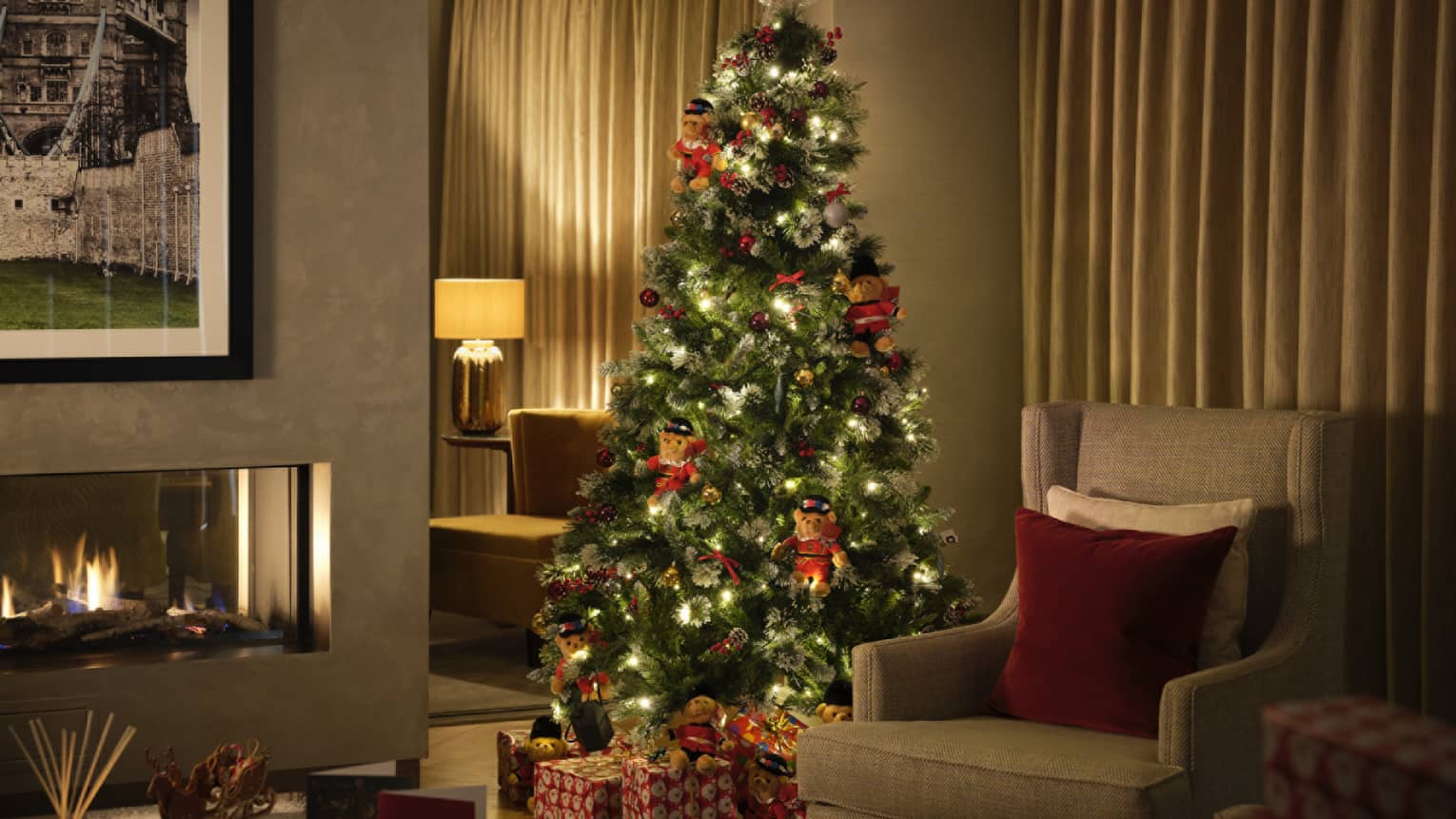 Christmas tree lit up in a dimly lit living room with fireplace
