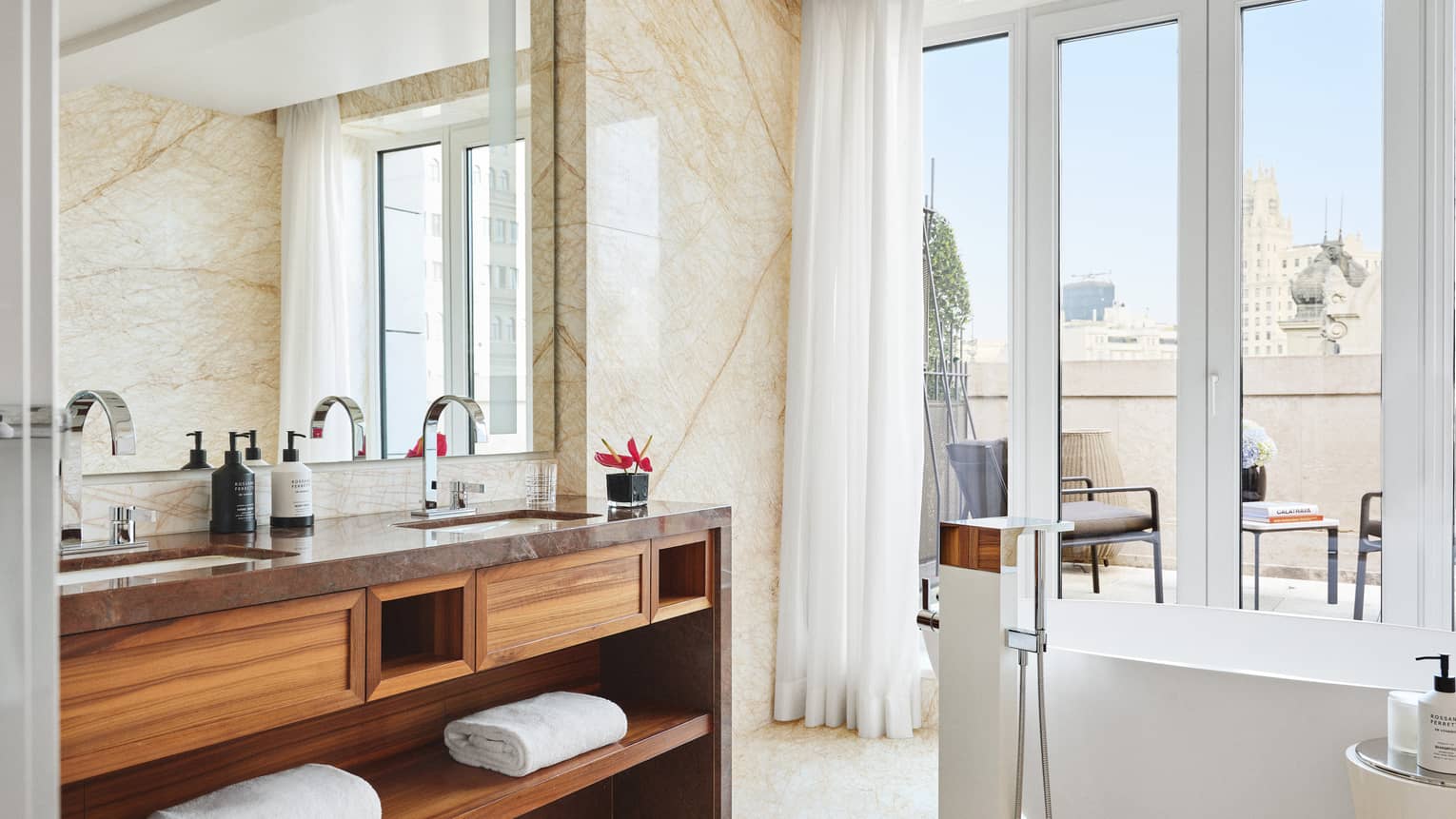 Marble bathroom of hotel suite, with walk-out terrace and standalone tub