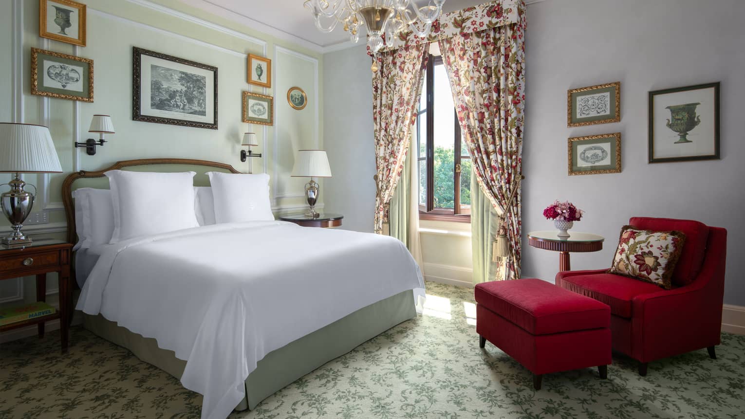 Luxury hotel room with king bed, red arm chair and ottoman, chandelier and elegant window curtains at Four Seasons Hotel Florence