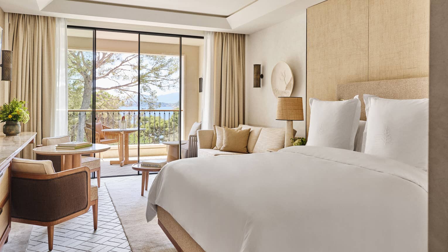 Luxury hotel room with king bed, windowside lounge seating and garden-view terrace at Four Seasons Resort Mallorca