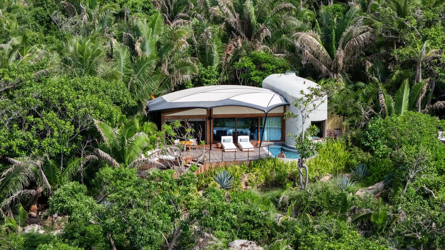 Secluded bungalow set in a lush, green tropical landscape