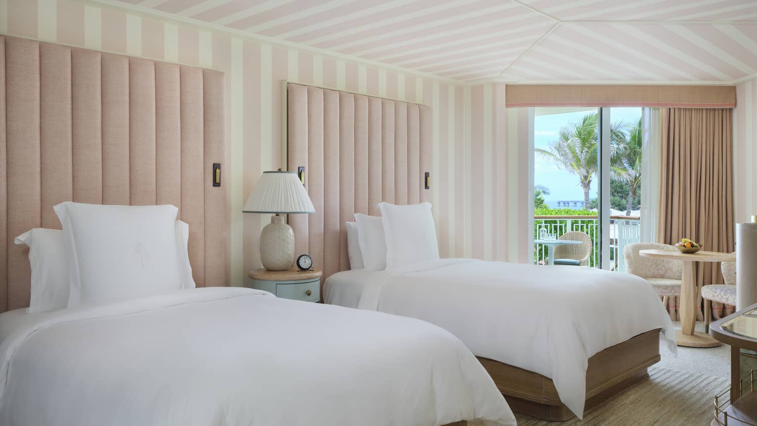 Luxury resort room with two single beds, light pink and white striped ceiling and walls, and balcony, at Four Seasons Resort Palm Beach
