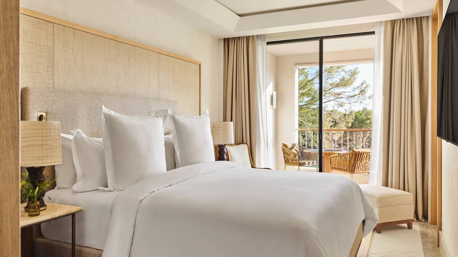 Luxury suite bedroom with king bed and walk-out balcony with garden view at Four Seasons Resort Mallorca