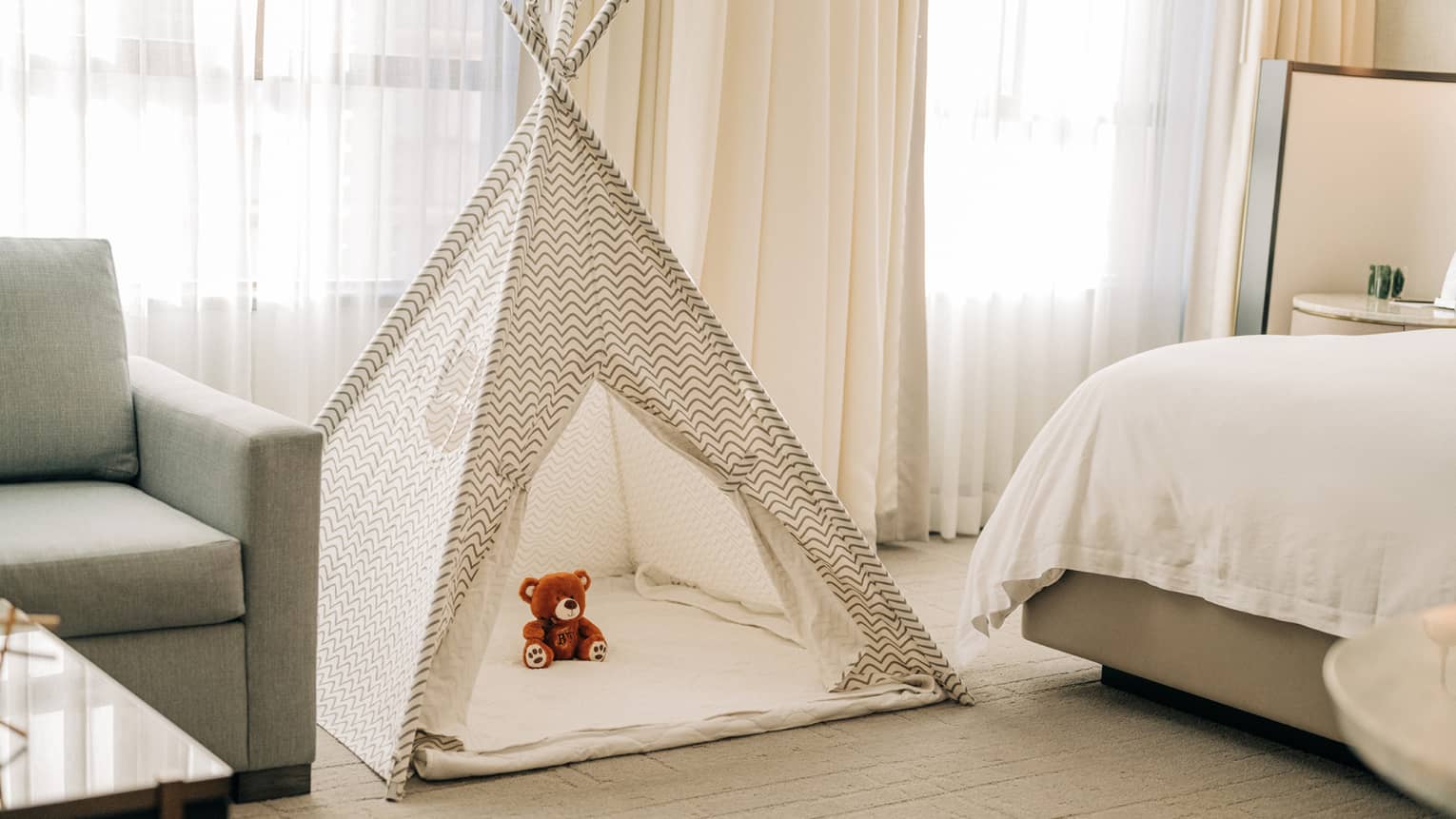 A kids tent with a stuffed animal in a guest room