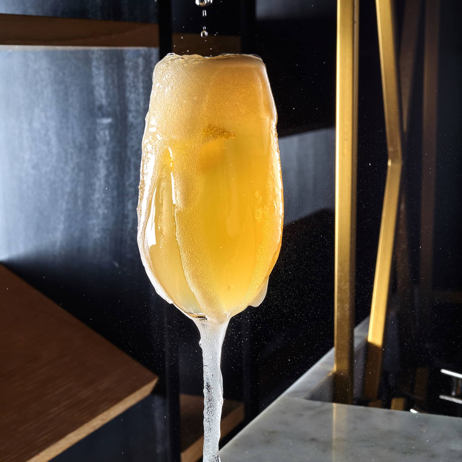 A champagne glass being filled with a drink