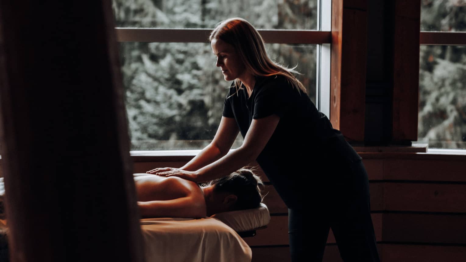 A woman receicing a massage in a dimly lit room.