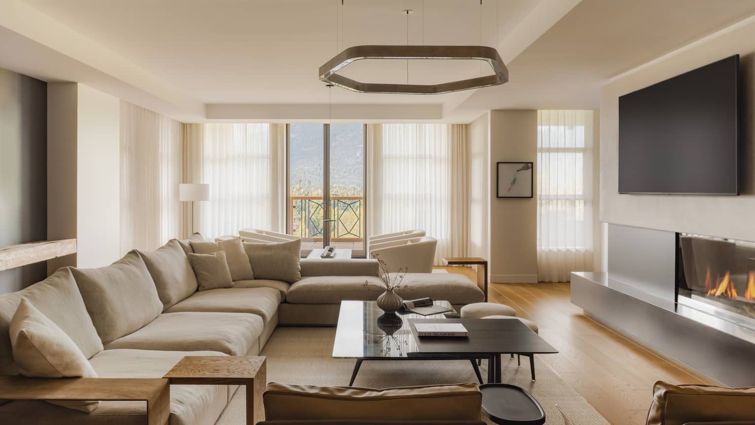 Modern living room of a mountain resort private residence, featuring large sectional sofa and fireplace