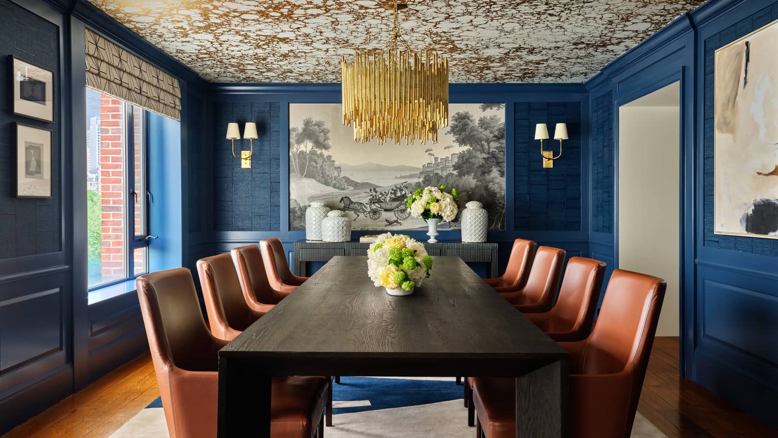 Stylish dining room with dark wood table, eight tan leather chairs, gold patterned ceiling and gold chandelier ? Royal Suite at Four Seasons Hotel Boston