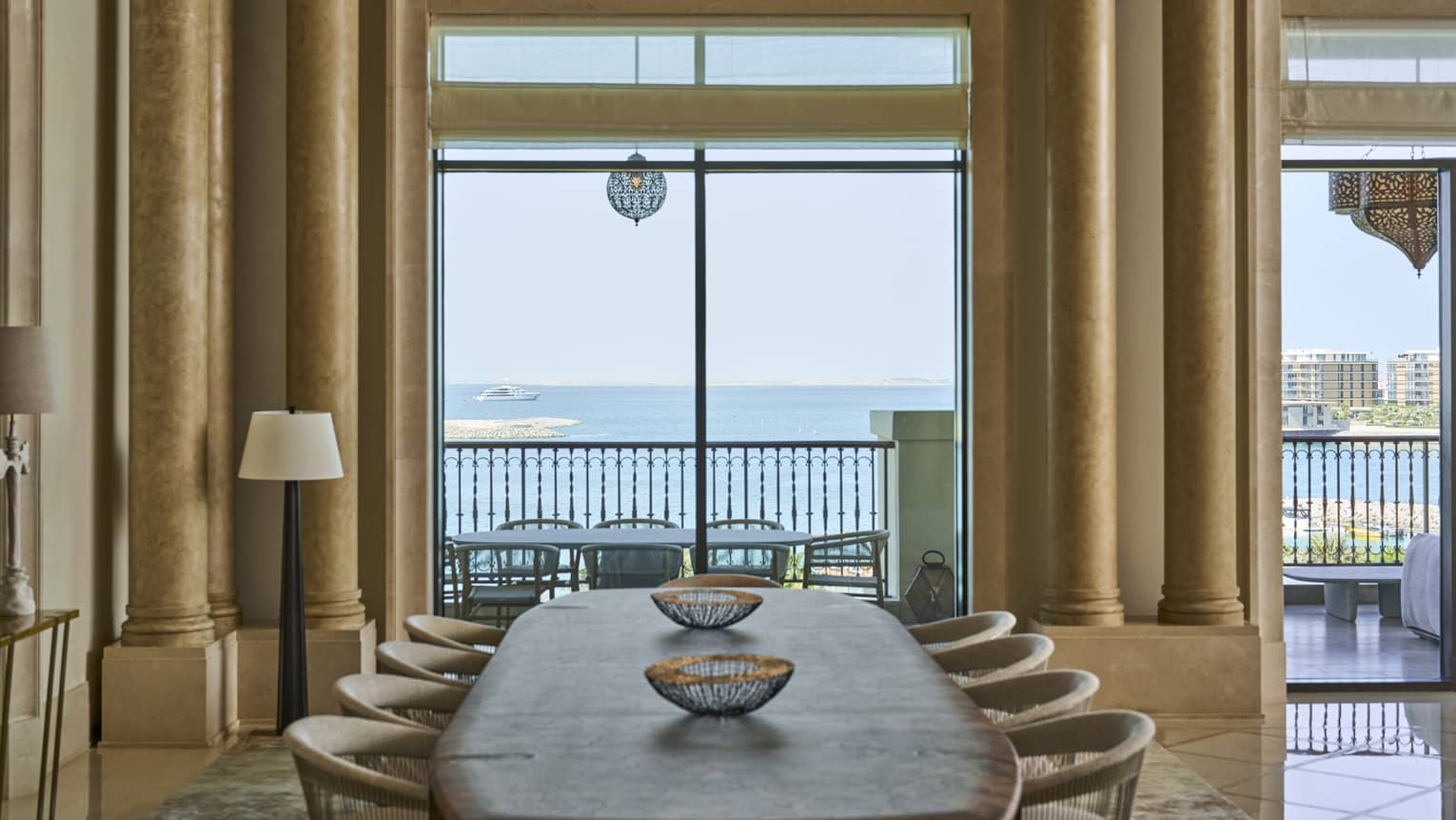 View of the sea through a dining room with a wooden dining table and eight chairs