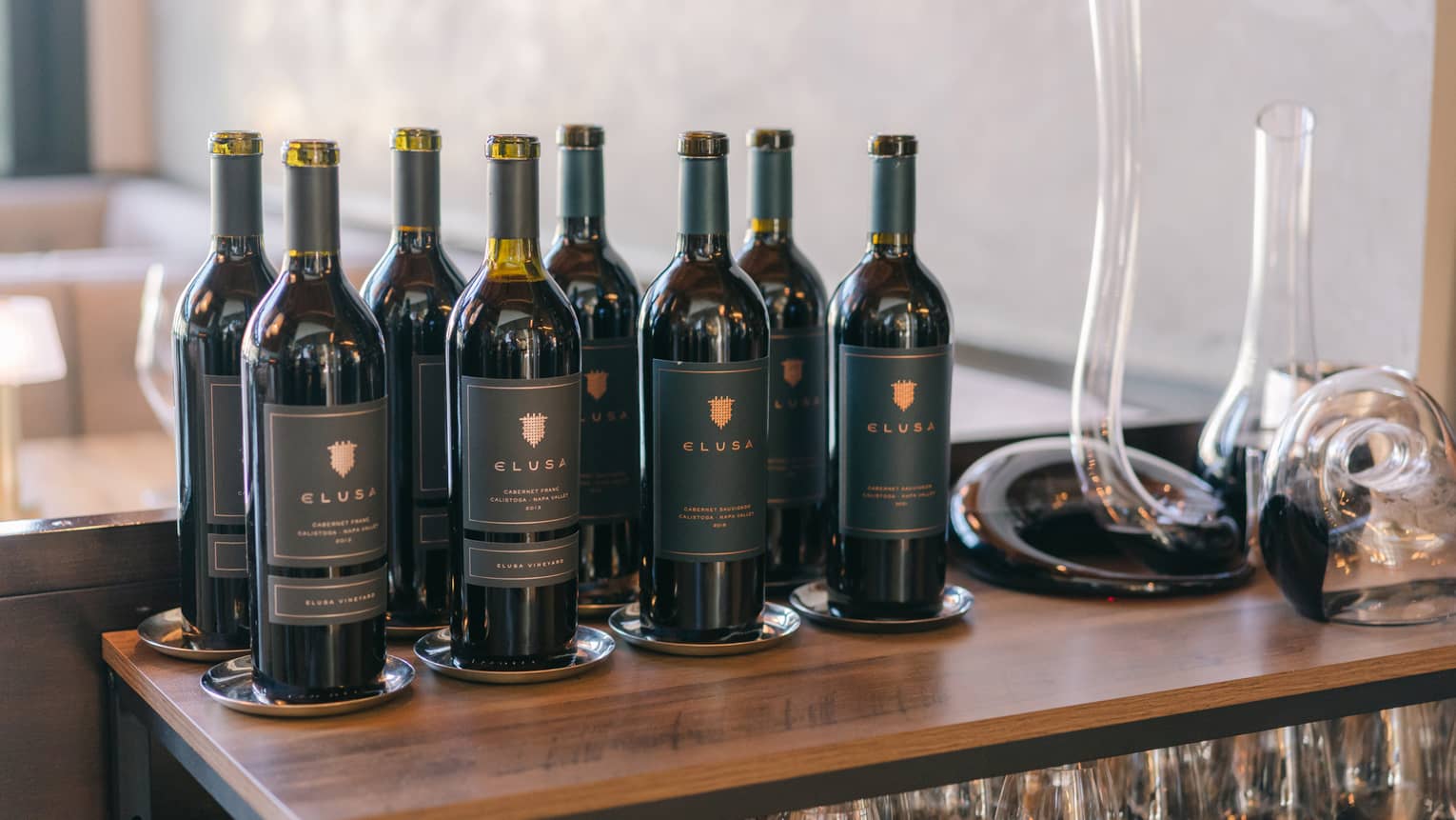 Wine bottles and a decanter on a wooden table