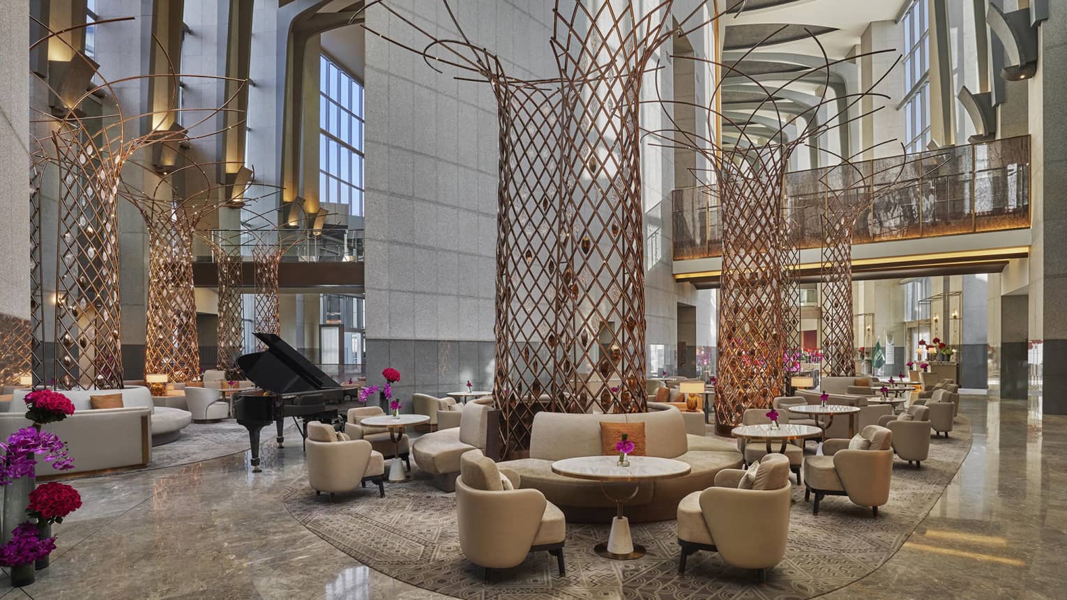 Lounge area set in hotel lobby with two-storey ceilings and tall, red wire scupltures